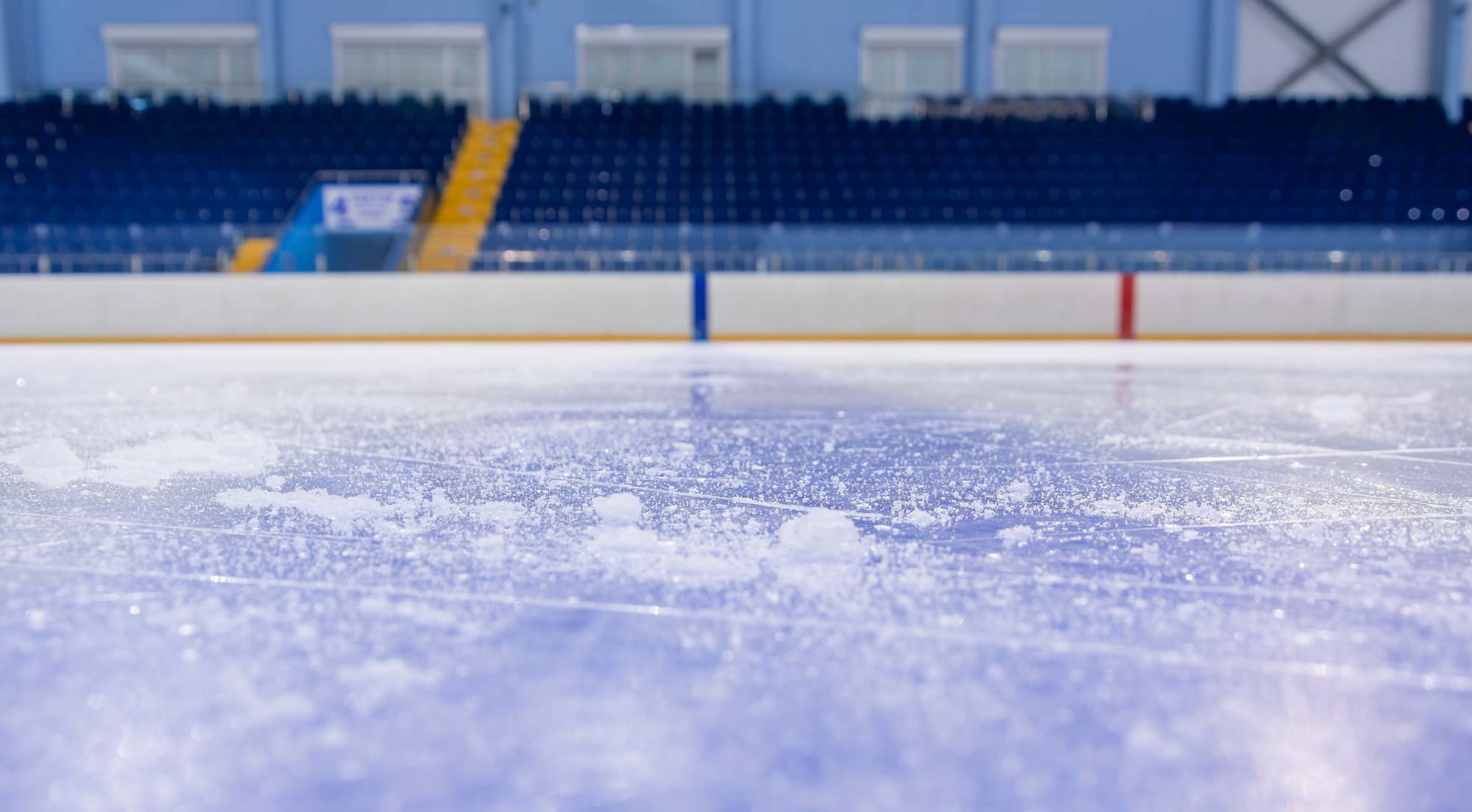 Tom hockeyarena med is och läktare